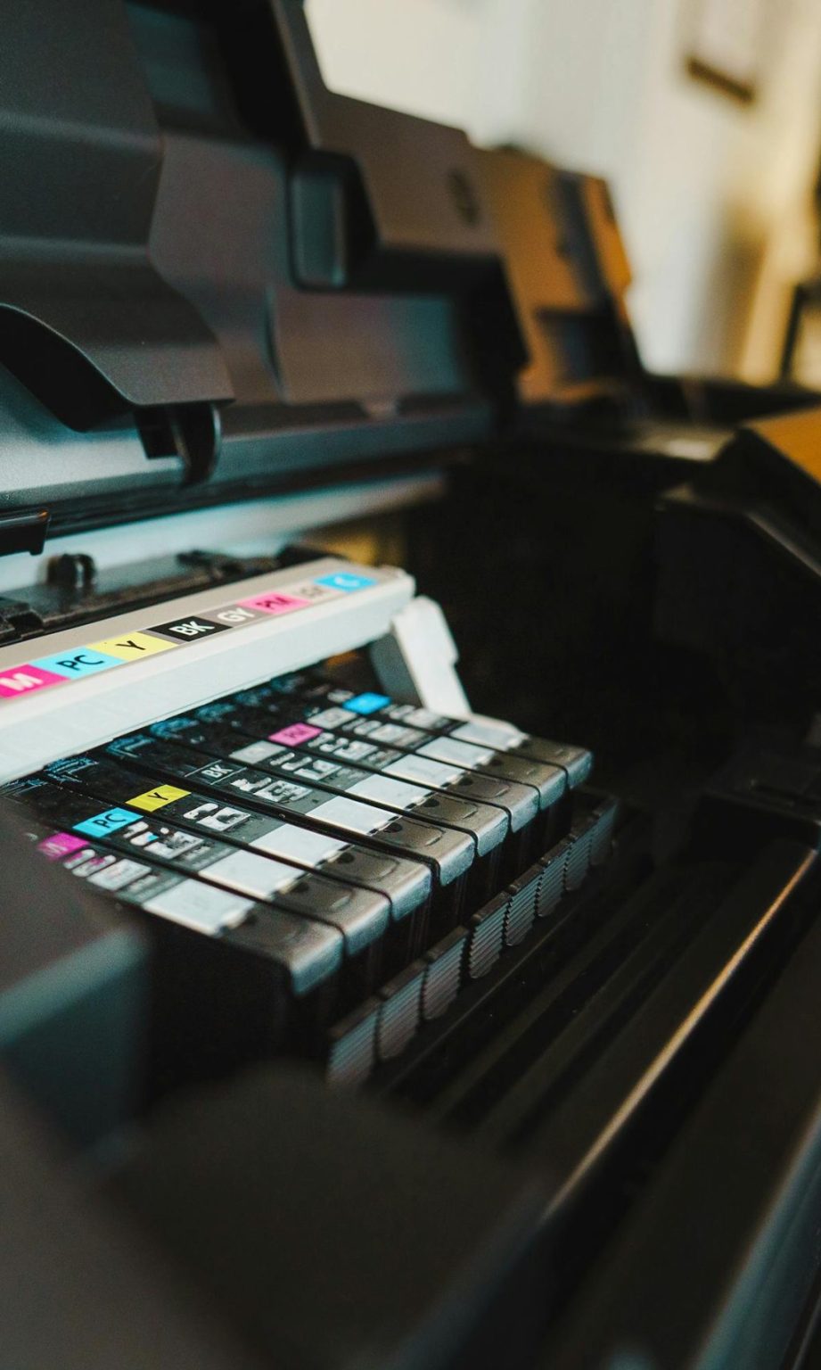 Detailed view of ink cartridges inside a digital inkjet printer in an office setting.