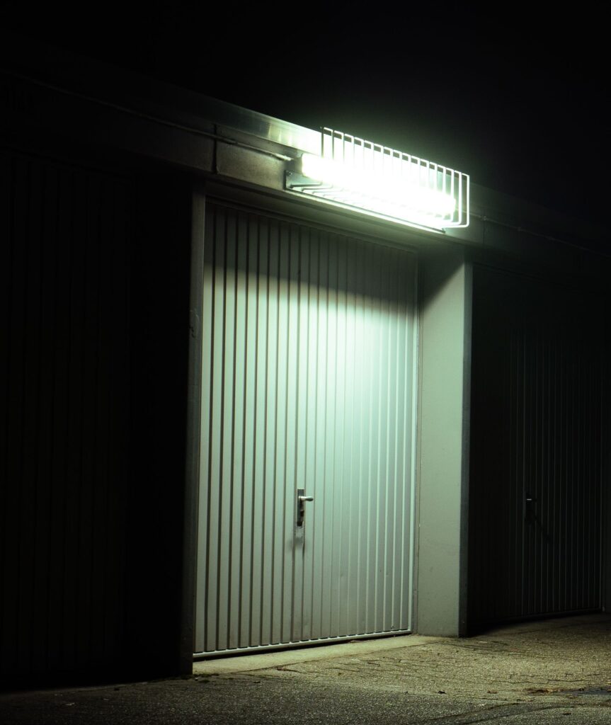 Słabo oświetlone drzwi garażowe podświetlone przez lampy wiszące w spokojnej nocnej scenerii w Niemczech