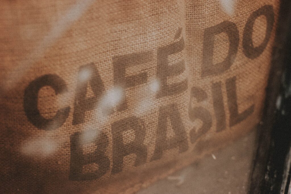Zbliżenie na worek jutowy z napisem 'CAFÉ DO BRASIL', oddające rustykalny motyw kawy